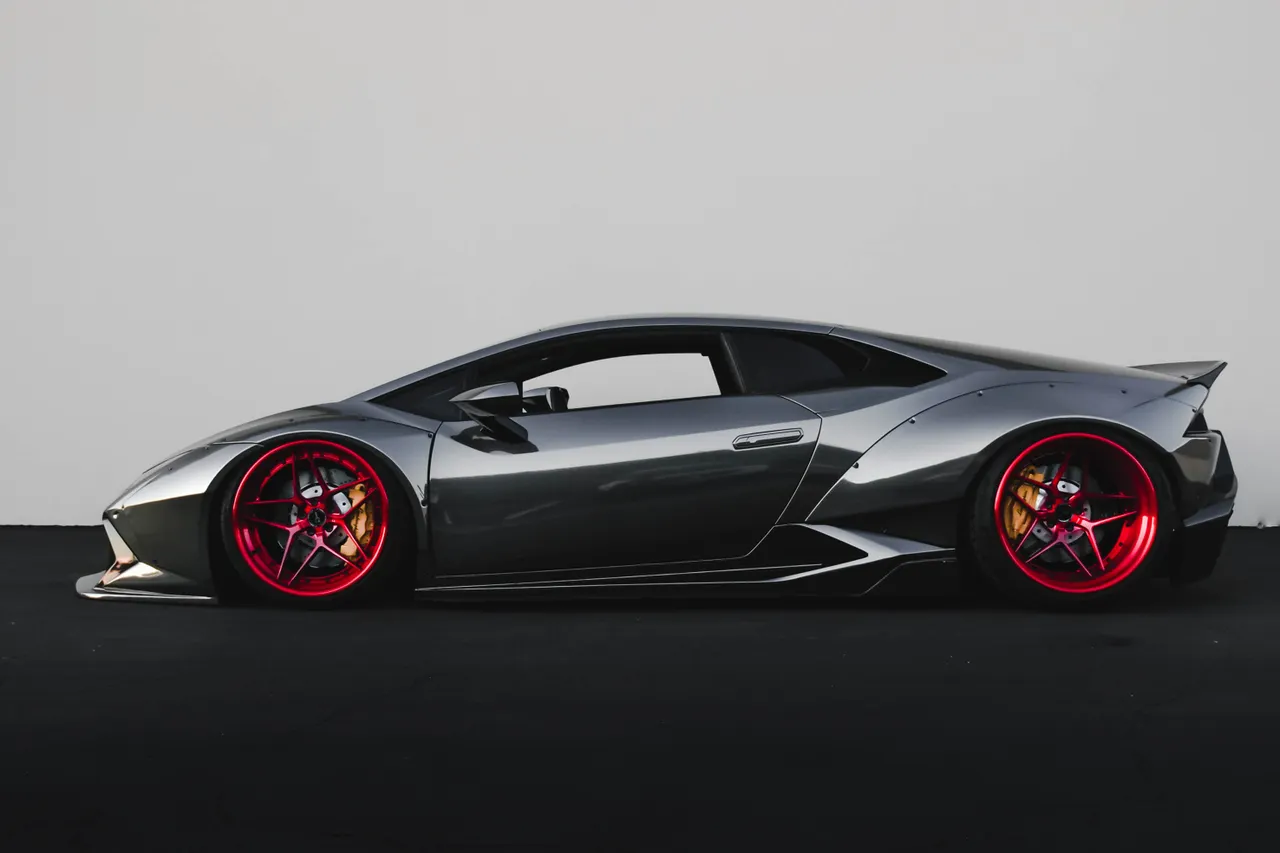 Voiture de sport grise photographiée de profil sur un fond neutre