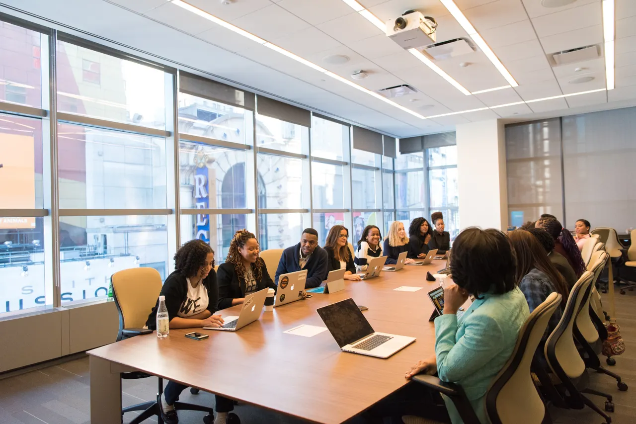 Groupe réuni autour d’une grande table de formation avec des ordinateurs