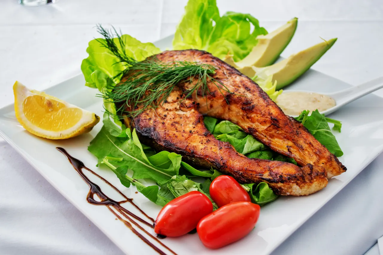 Pavé de saumon grillé accompagné de légumes, de citron et d’avocat