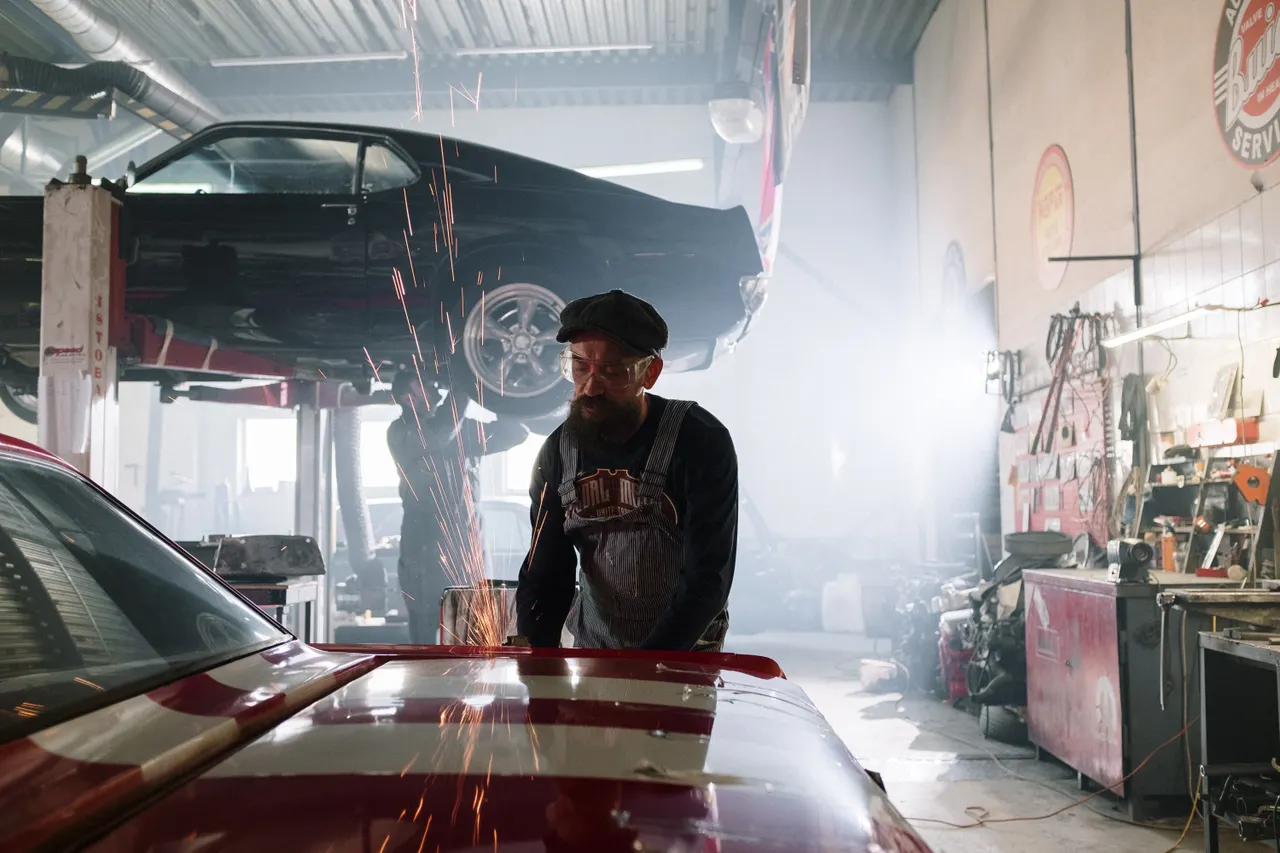 Technicien travaillant près d’une voiture dans un atelier automobile
